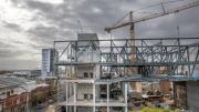A construction site with steel beams between two concrete towers.